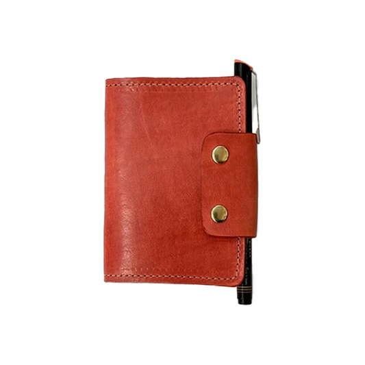 Red leather notebook with gold buttons on a white background