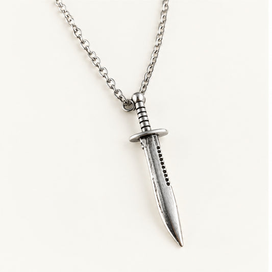 Close-up of the silver Bowie knife pendant showing crossguard, grip, and serrated spine