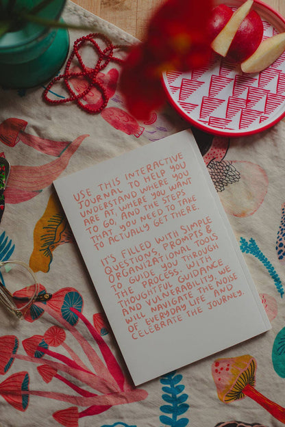 Hands holding the Make It Happen journal open to its introduction