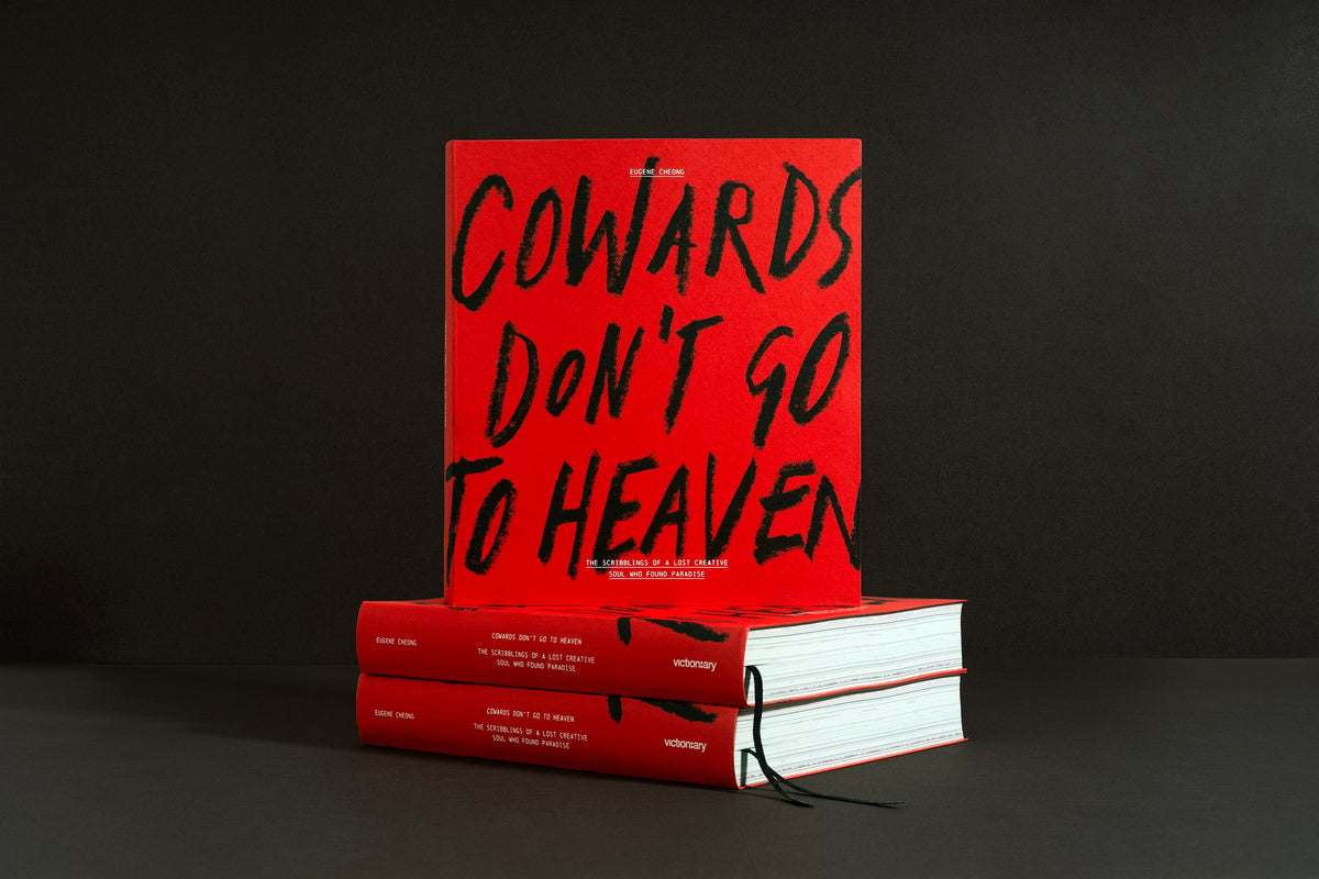 Cowards Don't Go to Heaven standing on a stack of copies