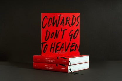 Cowards Don't Go to Heaven standing on a stack of copies