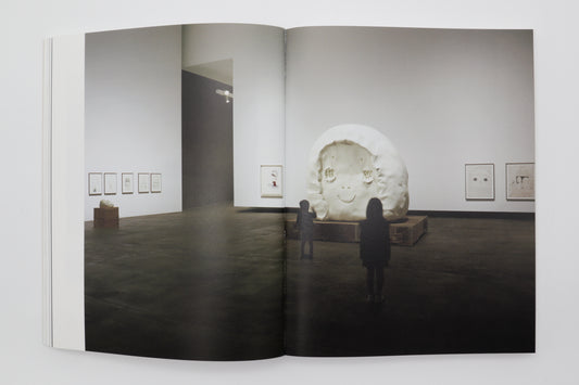 Spread from The Beginning Place showing a large white sculpture head in the Aomori Museum of Art gallery