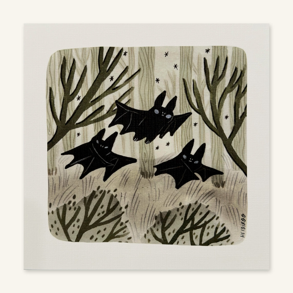 Three black bats flying through a sage-green forest of pale trees and bare branches with small stars, art print by Heidi Moreno shown flat