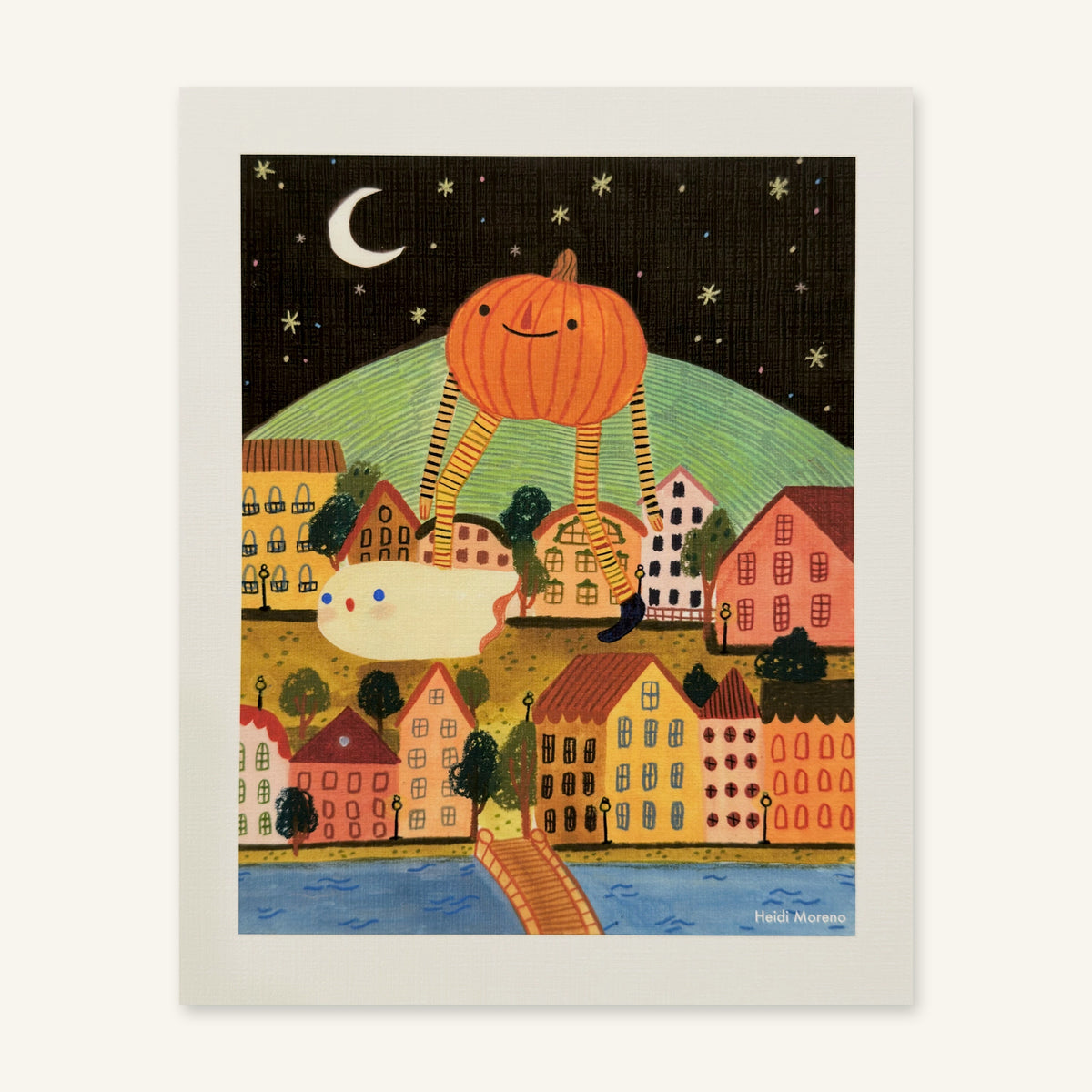Giant smiling pumpkin on long striped legs walking over a colorful hillside town at night with a small ghost and a crescent moon, art print by Heidi Moreno shown flat
