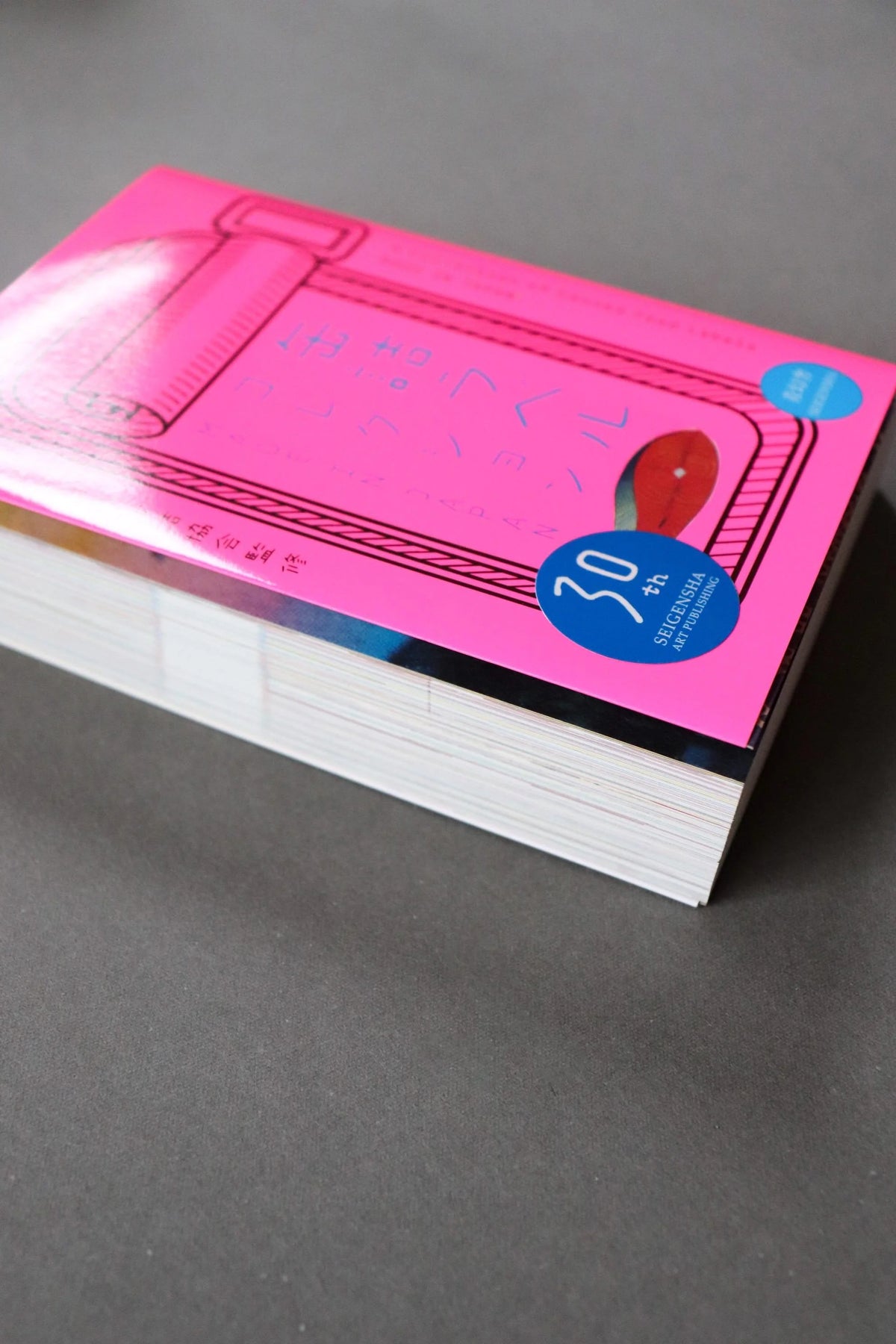 The pink cover of Made in Japan: A Collection of Canned Food Labels, showing the thick block of pages