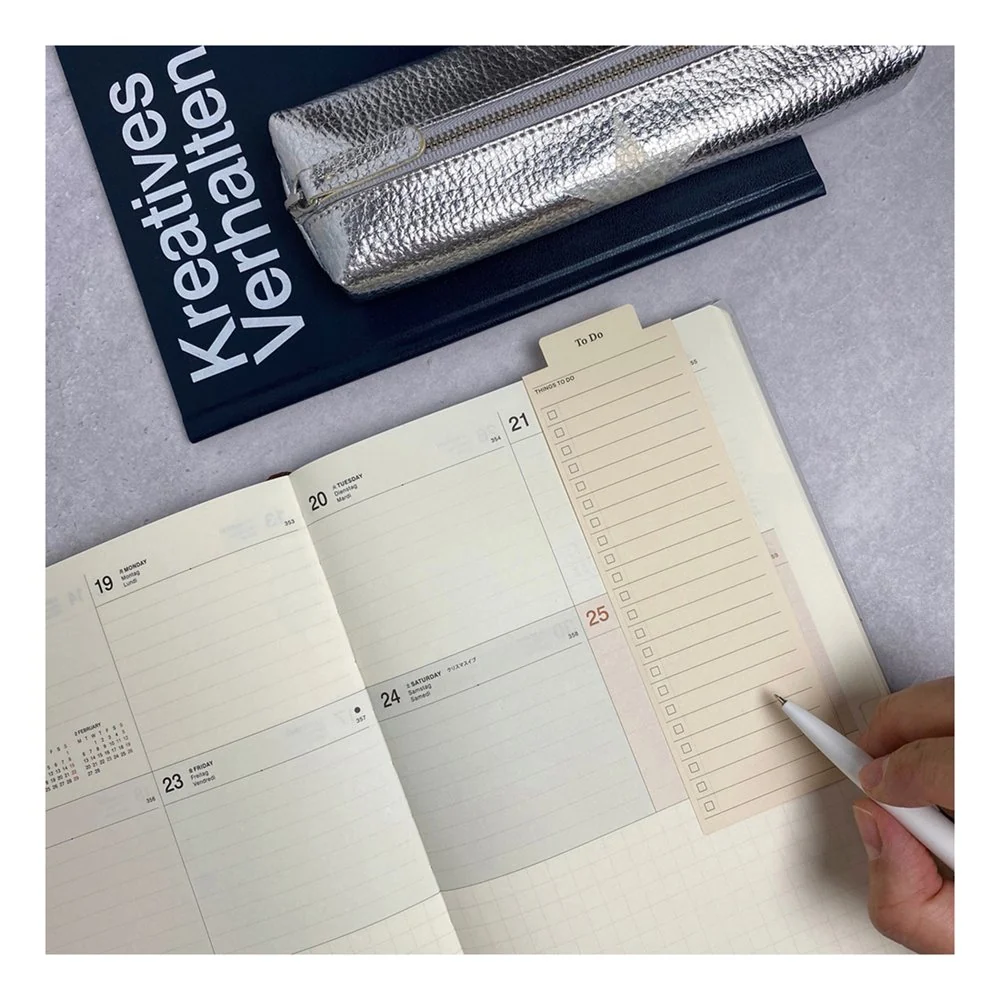 Laconic Style Bookmarker folded over a planner page