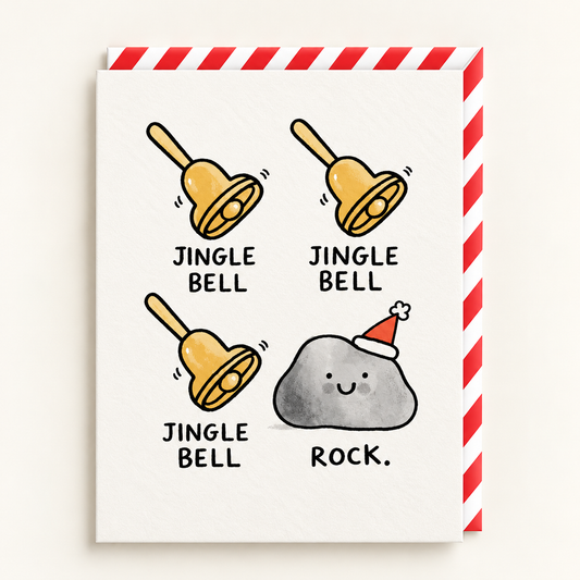 Jingle Bell Rock Christmas Card by Gemma Correll: three gold jingle bells and a smiling grey rock in a Santa hat on a cream card, with a red and white striped envelope
