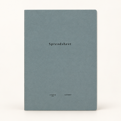 A square notebook with a textured slate blue cover and the word 'Spreadsheet' printed in black serif font in the center, set against a plain off-white background.