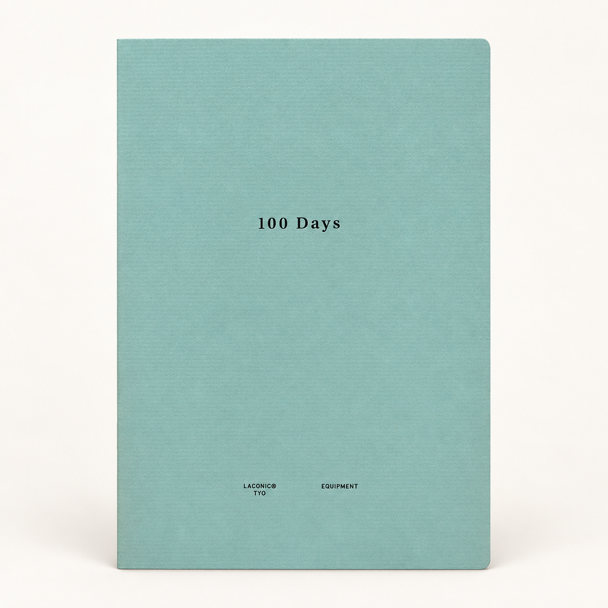 A hardcover notebook or journal with a textured light teal cover, featuring the title '100 Days' printed in black serif font in the center, and 'LACONIC EQUIPMENT' printed at the bottom. The notebook is photographed against a clean, off-white background.