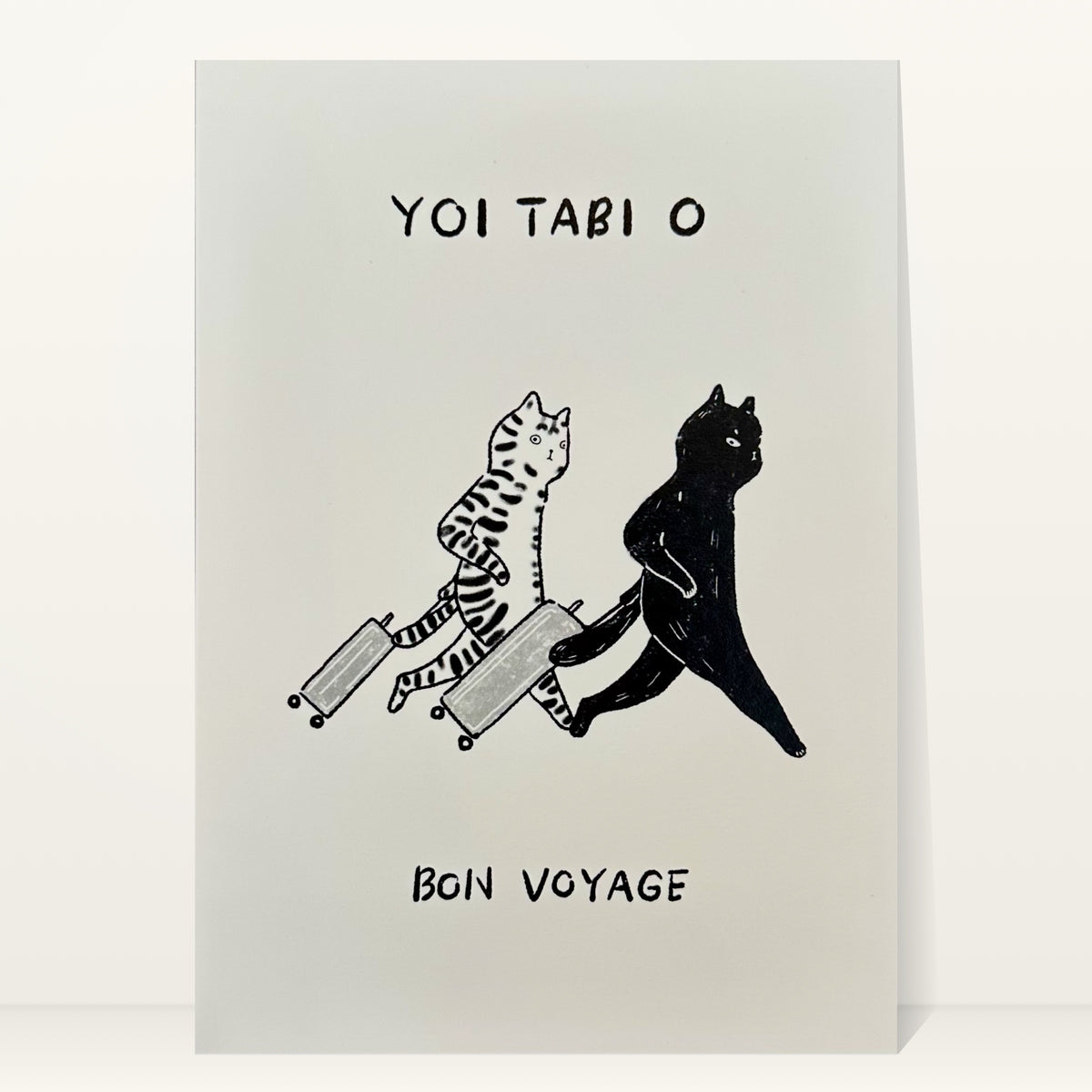 Bon Voyage mini art print by Linnan Ye: tabby cat and black cat striding off with rolling suitcases, with the words “Yoi tabi o” and “Bon voyage”
