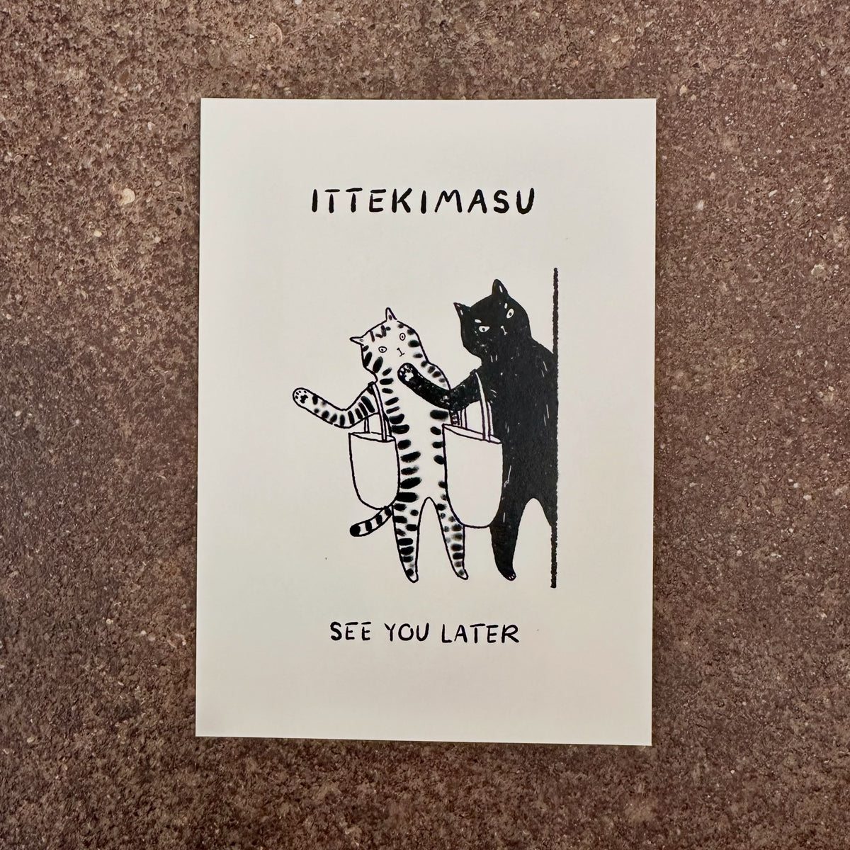 Ittekimasu mini art print by Linnan Ye photographed on a speckled stone surface
