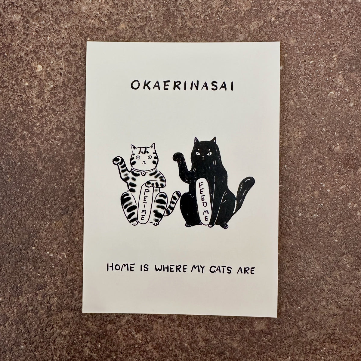 Okaerinasai mini art print by Linnan Ye photographed on a speckled stone surface