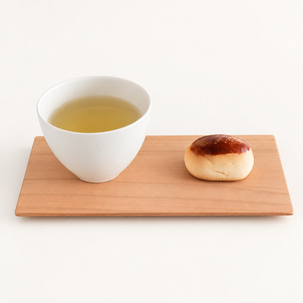 SALIU long cherry wood coaster holding a cup of green tea and a small pastry