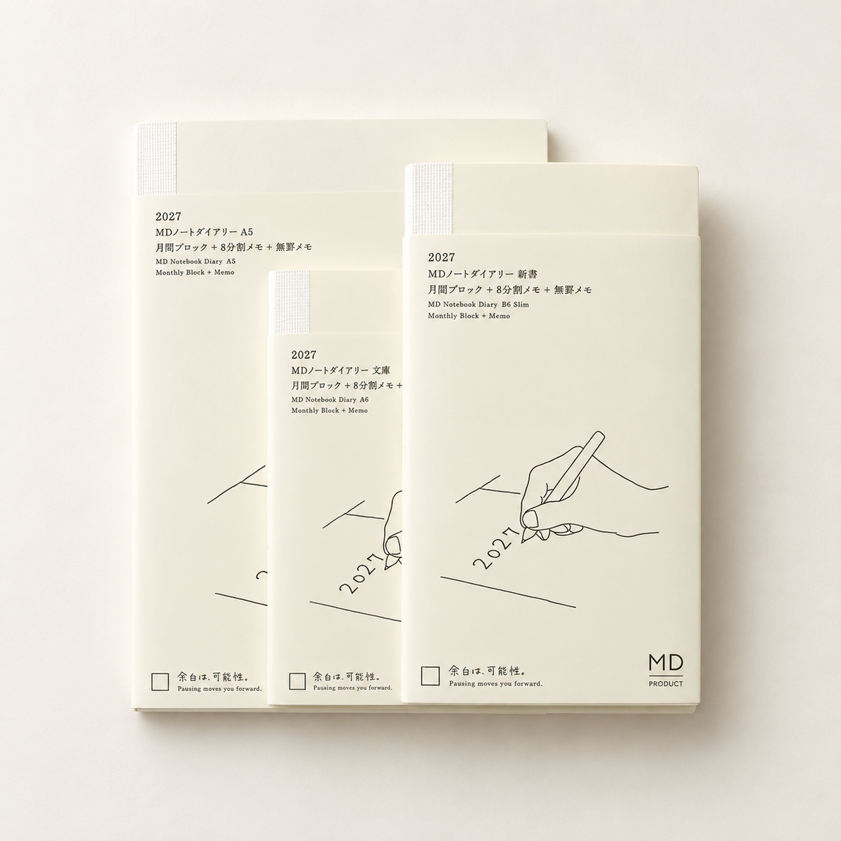 Three cream-colored MD Product notebooks with minimalist black line drawings and Japanese text, arranged in a fan-like stack on a light beige background.
