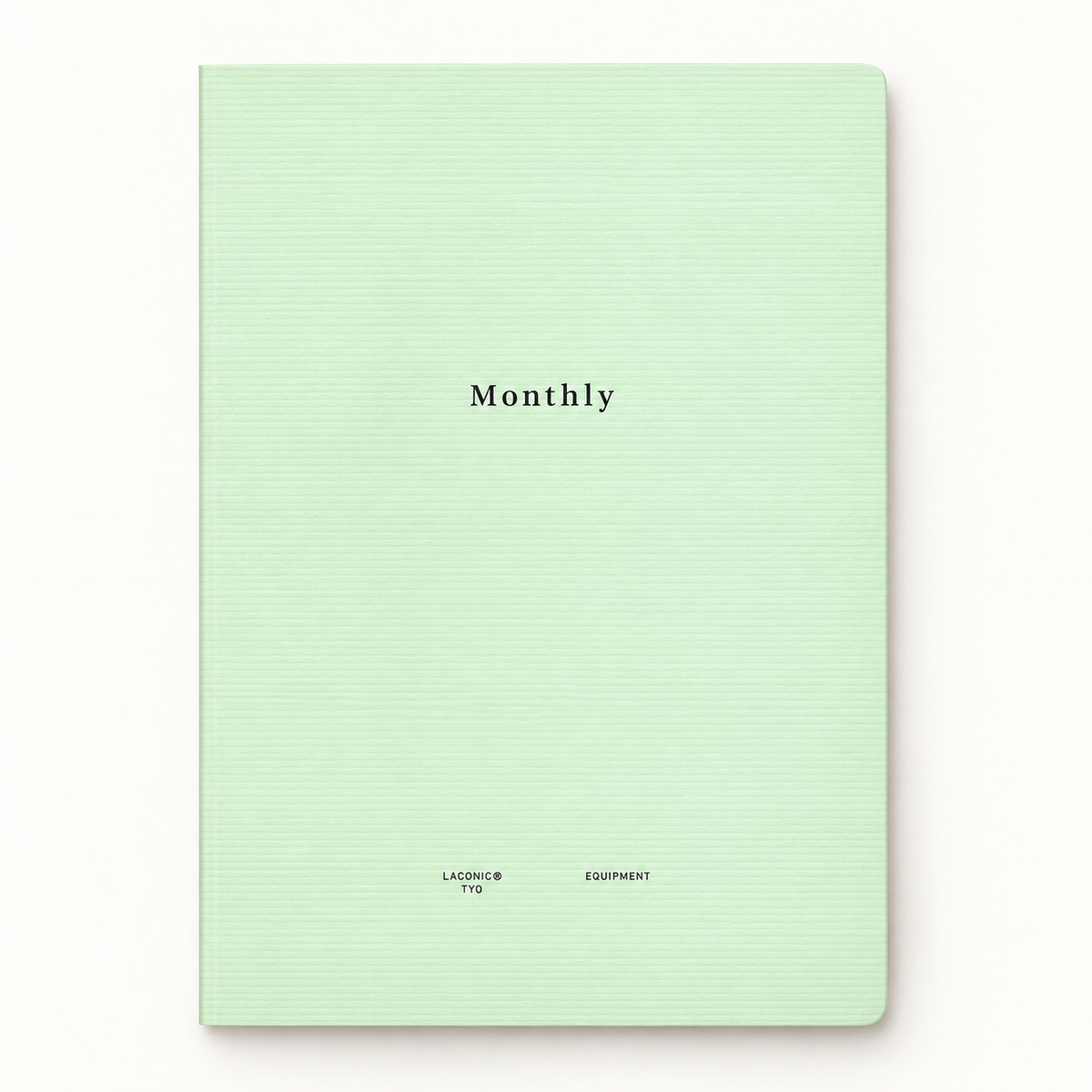 A mint green hardcover notebook with a subtle horizontal ribbed texture, featuring the word 'Monthly' printed in black serif font in the center and small text at the bottom.