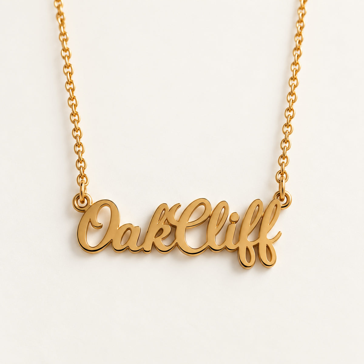 Close-up of the gold Oak Cliff script pendant