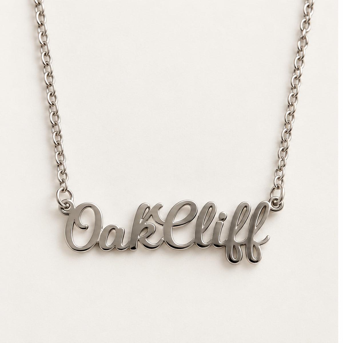Close-up of the silver Oak Cliff script pendant
