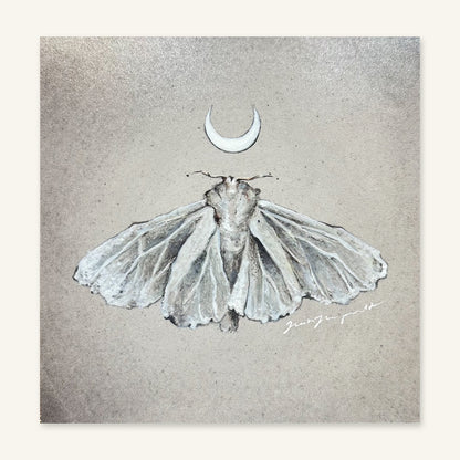 The White Moth art print by Trisha Thompson Adams photographed flat, showing the full artwork: a silvery moth and crescent moon on a stone-grey ground