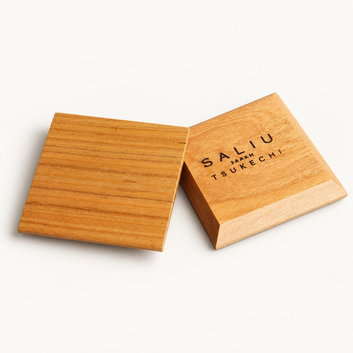 Two square Yamazakura cherry wood coasters by SALIU, one showing the SALIU Japan Tsukechi brand mark